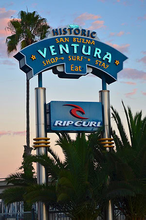 The Ventura pole sign sits next to the 101 freeway. It invites drivers to Shop, Surf, Stay, and Eat in Historic San Buena Ventura.