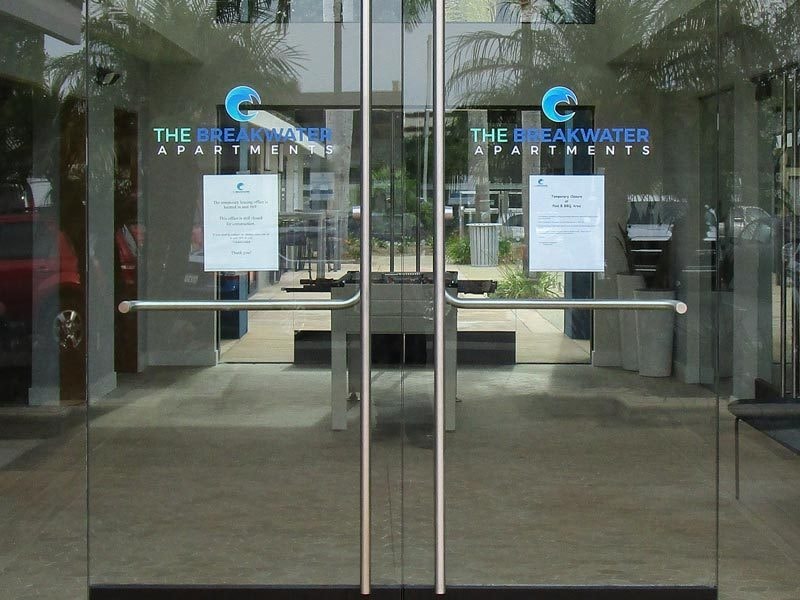 Window graphics are great for glass doors like these for The Breakwater Apartments in Huntington Beach.