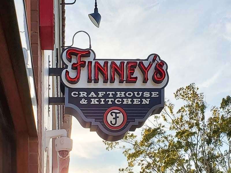 Finneys projecting blade sign with open face neon-lit channel lettering in San Luis Obsipo, California.