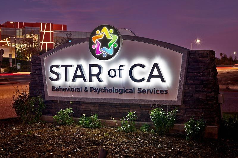 Star of CA illuminated monument sign with reverse-lit channel letters in Ventura, California at dusk.