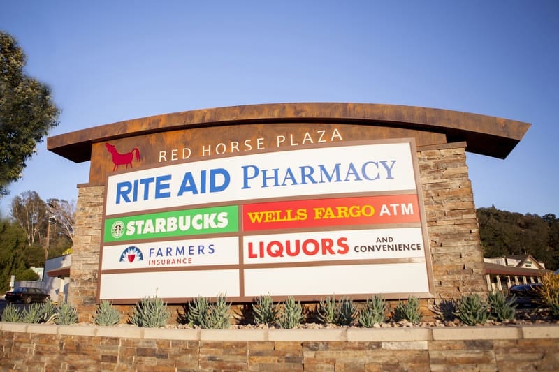 The Red Horse Plaza masonry monument sign uses stone and lightbox panels for illumination in Ojai, California.